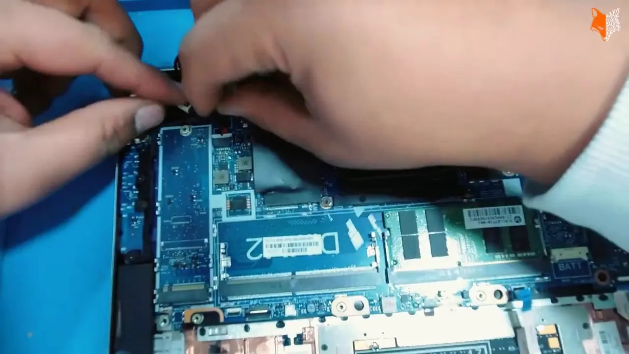 Hände entriegeln das Tastatur-Flachbandkabel am Mainboard des HP EliteBook 835 G8